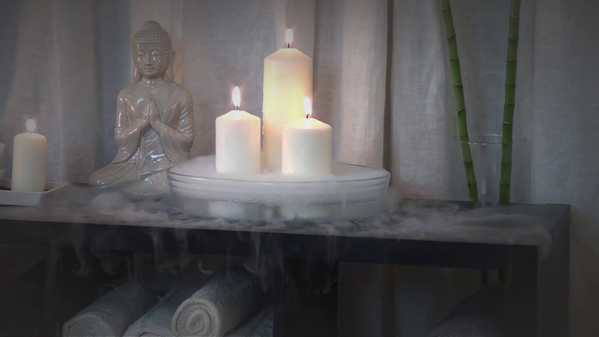 Candles burning beside a stone Buddha in the massage studio, Playa del Ingles